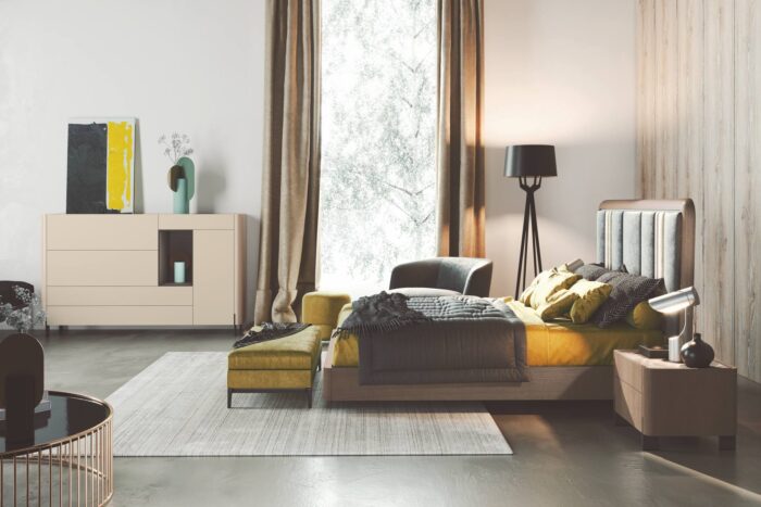 Lit double vue de profil dans une grande chambre aux matières et coloris design